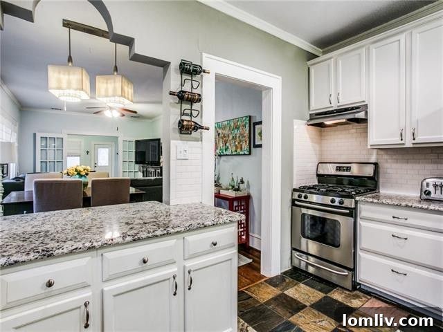 Contemporary white kitchen with stainless steel appliances and granite countertops.