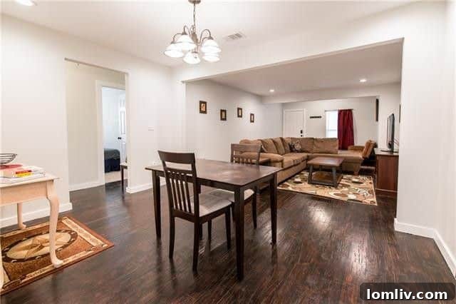 Open concept living area with hardwood floors in renovated Oak Cliff home