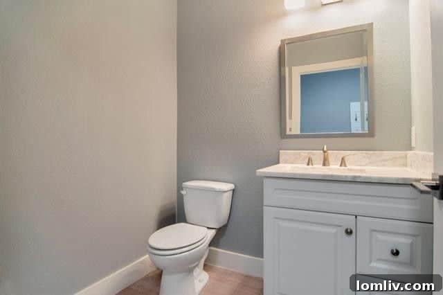 Elegant powder room with contemporary fixtures and a sleek vanity, offering convenience and style for residents and guests