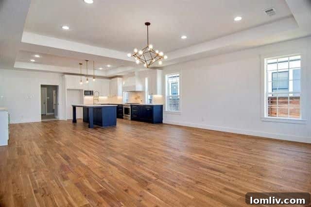 View from the living room towards the modern kitchen, highlighting the seamless flow of the open floor plan and the ample natural light