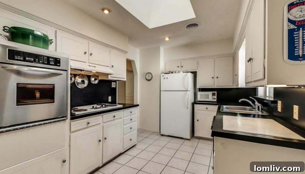 Kitchen view inside the Old Lake Highlands home, showcasing a skylight and classic cabinetry.