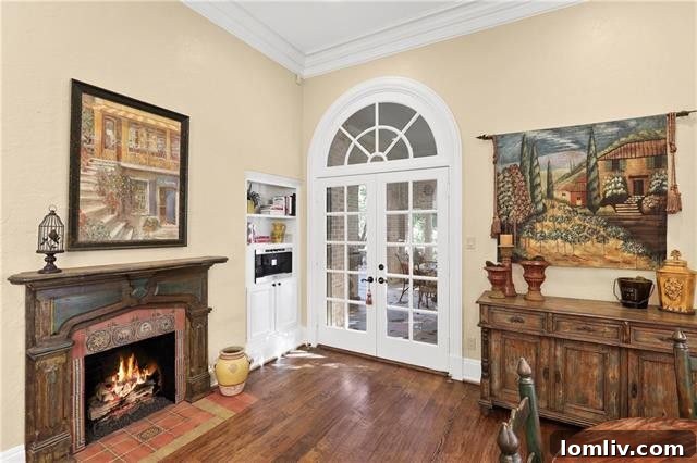 The gourmet kitchen, boasting a charming fireplace and French doors leading to an outdoor terrace with stunning views of White Rock Lake.