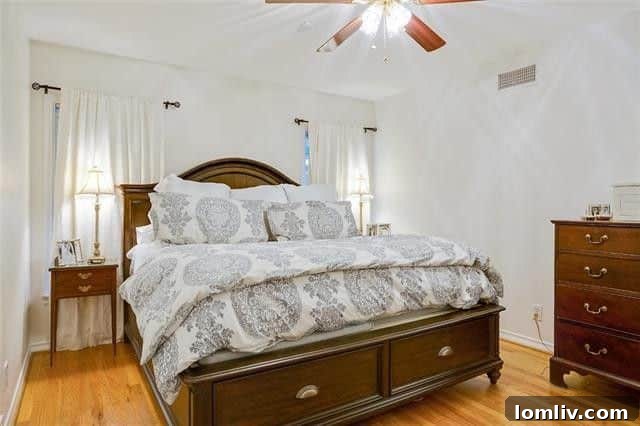 Spacious master bedroom with tall windows, offering abundant natural light.
