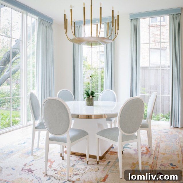 Living room with soft blue designer draperies and brushed brass chandelier.