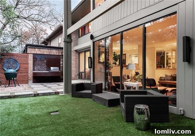 Outdoor kitchen area with gas grill and artificial turf yard at 8849 McCraw Drive