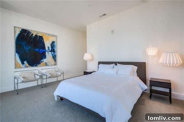 Primary bedroom with contemporary art and city skyline through windows