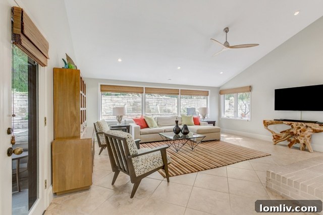 Open concept family room flowing into the kitchen and breakfast area, with views of outdoor entertaining space