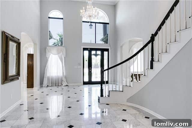 Interior view of the grand marble entry and sweeping staircase, showcasing the luxurious design of the Abrams Road home.