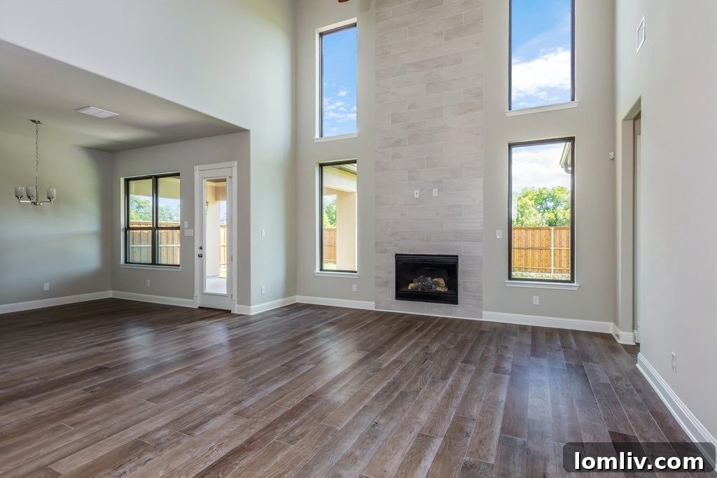 Bright and airy double-height great room with large windows and a fireplace