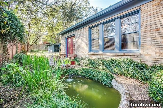 Secluded back lawn with lush landscaping and a tranquil pond, perfect for relaxation