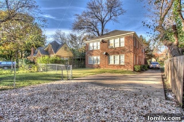 Exterior view of a multi-unit brick property on a tree-lined street in Old East Dallas