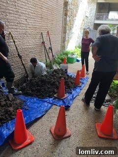 Workers repairing a sewer leak on a blue tarp outside Diplomat Condos