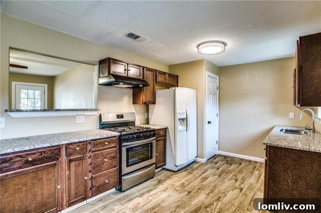Modern galley kitchen with granite countertops and stainless steel appliances at 3407 Palm Drive