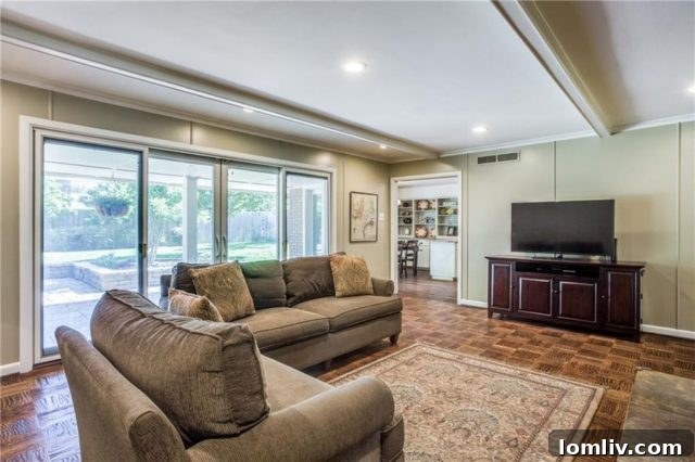 Kramer Zoned Dream Home Steps to School 7 Cozy family room with stone fireplace, exposed beams, and French doors to the patio