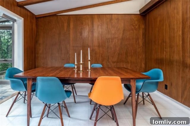 Open kitchen and dining area in a Mid-Century Modern home with vintage cabinetry and warm lighting
