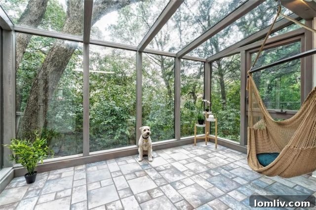 Bright glassed-in sunroom offering serene views and natural light in a Mid-Century Modern home