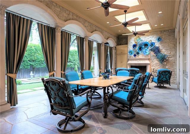 Opulent French Stone Manor Heads to No-Reserve Auction 9 Outdoor Living Space - Covered Loggia with Fireplace and Seating
