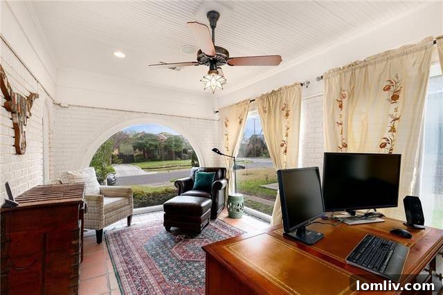 Elegant home office with built-in bookcases and large arched windows