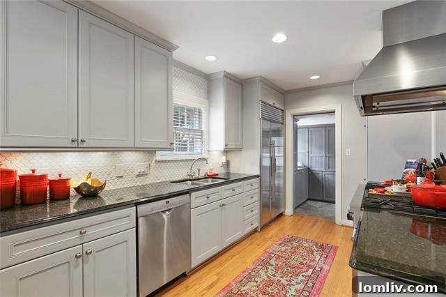 Gourmet eat-in kitchen with top-tier Sub-Zero and Viking appliances, unique fish-scale tile backsplash, and large island with seating