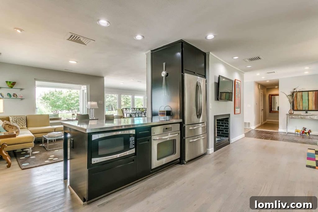 Midcentury Chic in Ridglea Hills Designed for Dazzling Gatherings 7 Fantastic flow from kitchen to living to dining areas, featuring a double-sided fireplace.