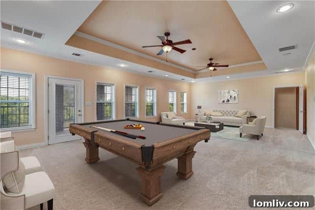 Large game room with balcony access overlooking the backyard pond in Rockwall home