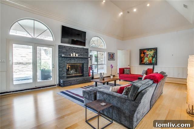 Spacious Oak Cliff Contemporary: Built for Bliss, Designed for Downtime 4 An opulent living room at 731 Kessler Lake Drive, featuring dramatic vaulted ceilings, a cozy fireplace, and abundant natural light from arched windows.