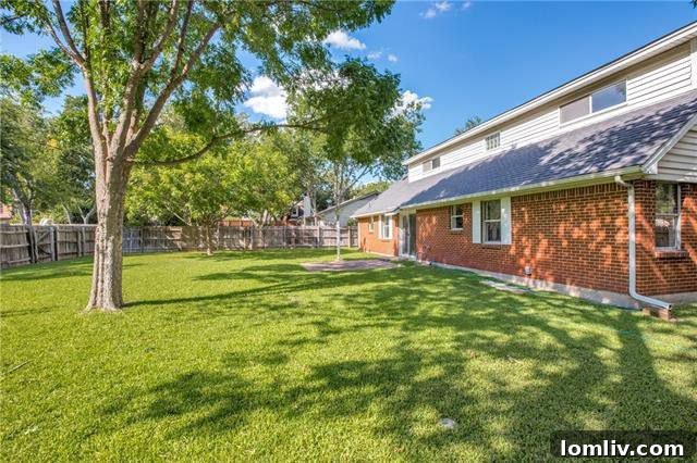 Fenced backyard with mature trees, offering a private and secure space for outdoor activities and relaxation at the Starter Home.