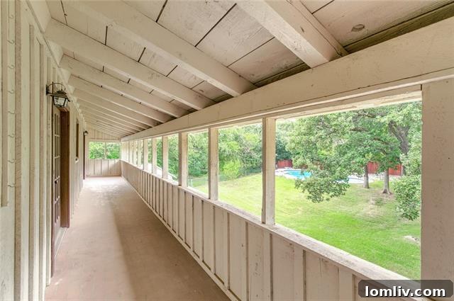 View of the expansive backyard and pool area at 5909 Monterrey Lane, showing lush trees and hardscaping