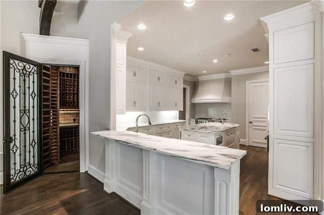 High-end chef's kitchen with marble countertops, large island, Wolf range, and SubZero refrigerator