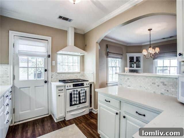 Bright and spacious living area with classic archways and hardwood floors in a Dallas cottage