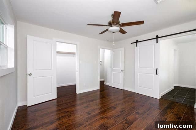 Master bedroom with a sliding barn-style door leading to the master bathroom at 2962 Satsuma Drive.