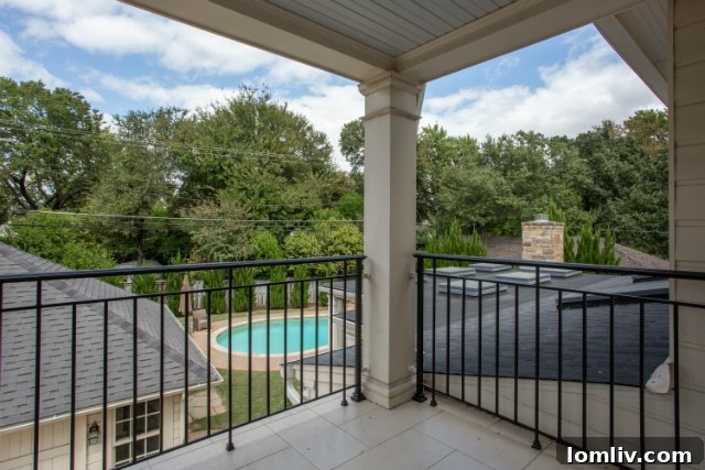Luxurious master suite with private sitting area and access to an exclusive outdoor terrace overlooking the lush backyard and sparkling pool