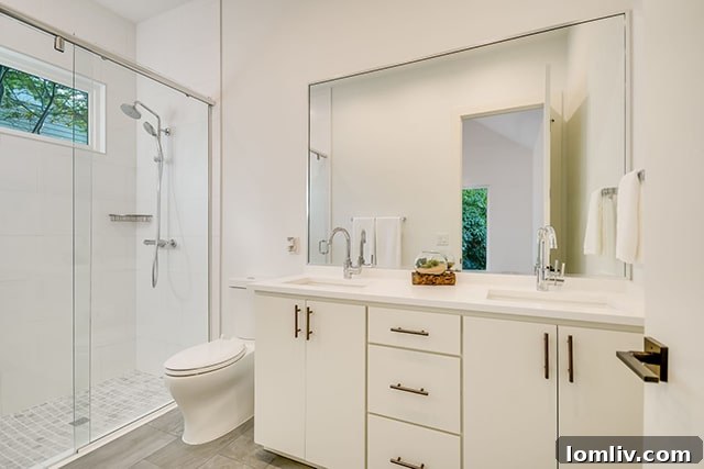 Pristine white master bathroom with dual vanity and modern fixtures.