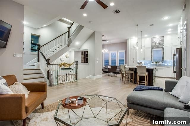 Modern open concept living area with high ceilings and hardwood floors