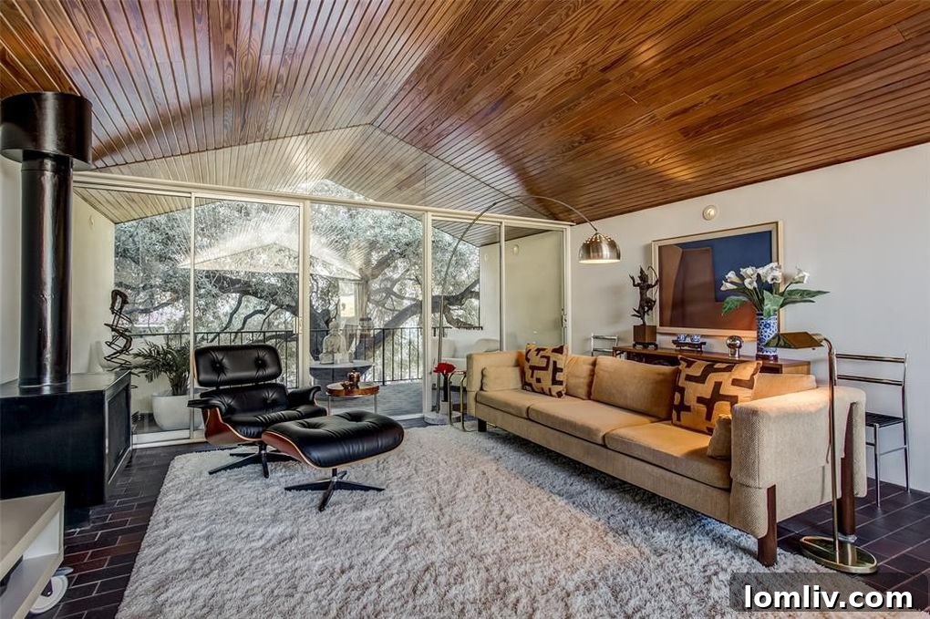 Upstairs living area of 2711 Hood Street, Unit E, with walls of glass overlooking mature oak trees