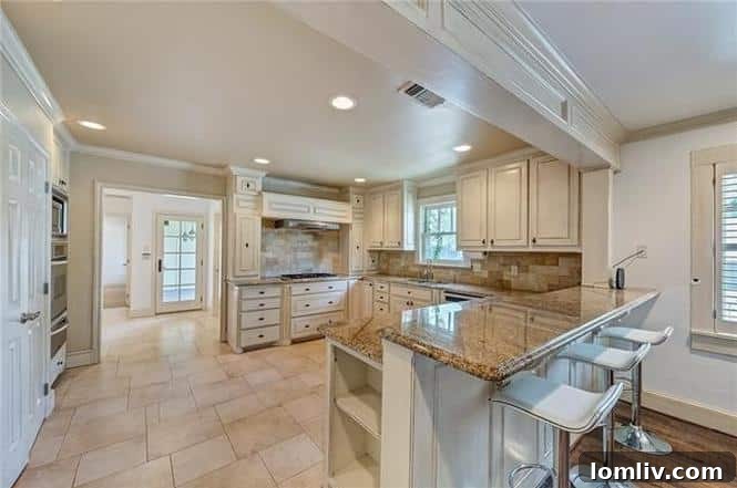 View from the open dining area towards the sophisticated kitchen at 1200 Clover Lane, featuring elegant design.