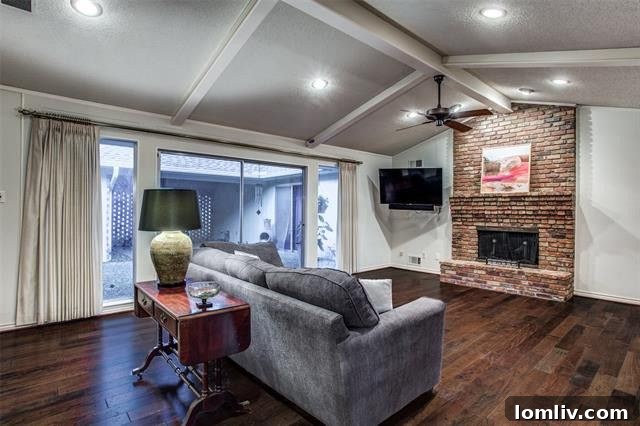 Bright and airy living area with vaulted ceilings and a handsome brick fireplace at 9447 Viewside Drive.