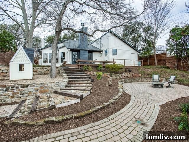 Expansive backyard with large deck, stone pathways, and mature trees