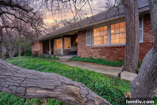 Elegantly framed exterior of a classic mid-century modern home in Crestwood, Fort Worth, nestled among mature trees.