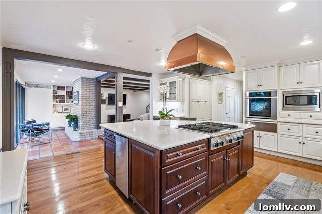 Spacious, modern kitchen featuring an oversized island with a gas cooktop, integrated appliances, and elegant finishes.