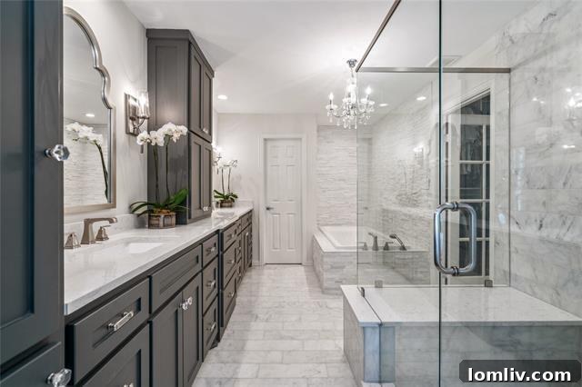 Opulent bathroom showcasing stunning Carrara marble on countertops, walls, and floors, with a large walk-in shower.