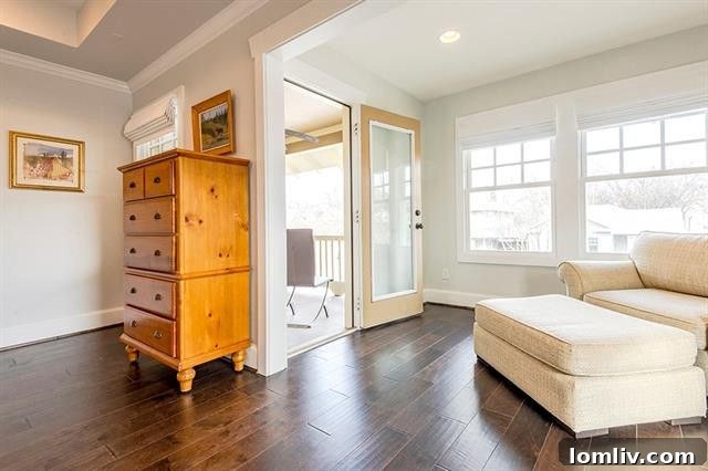 Elegant master bedroom with a tray ceiling, fireplace, and balcony access