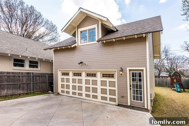 Gated driveway leading to a two-car garage and a spacious backyard