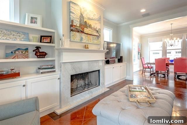 Spacious living room featuring a luxurious marble fireplace and built-in bookshelves