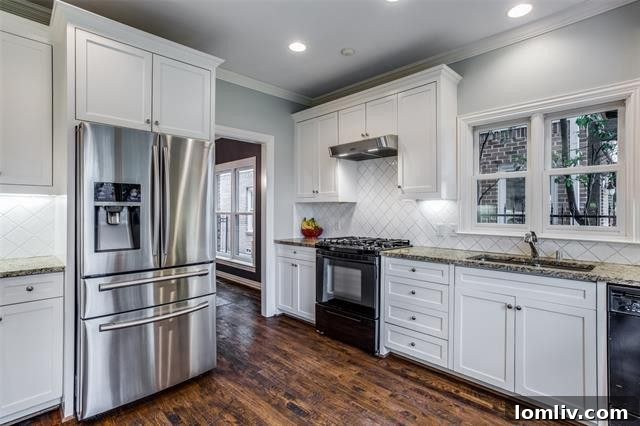 Modern kitchen with white cabinets, granite countertops, and stainless steel appliances