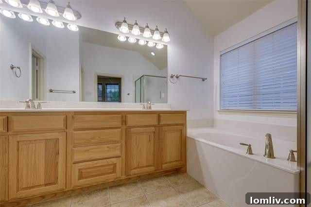 Luxurious master bathroom with dual sinks, a large soaking tub, and a separate shower