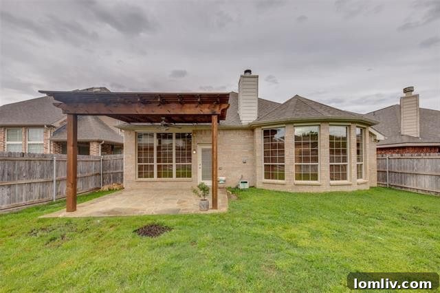 Backyard patio with a pergola, perfect for outdoor dining and relaxation in Grand Prairie