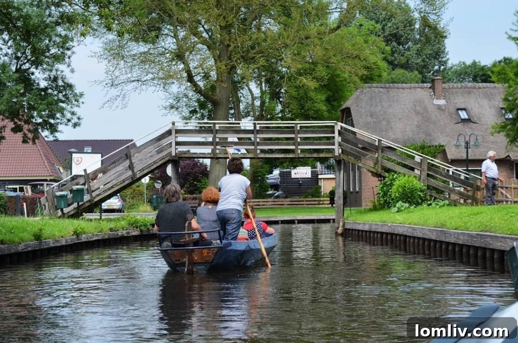 A Giethoorn home with a small bridge and lush gardens along a canal