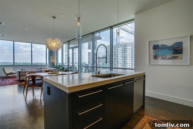 Modern kitchen with marble countertops, a large island, and high-end stainless steel appliances.