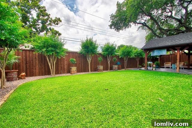 Expansive and private backyard oasis at Boca Bay Drive, featuring a covered patio, large wooden deck, lush lawn, and mature trees for ultimate relaxation and entertaining.